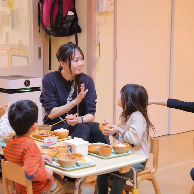 園児と一緒に給食を食べる保育士（世田谷はっと保育園）