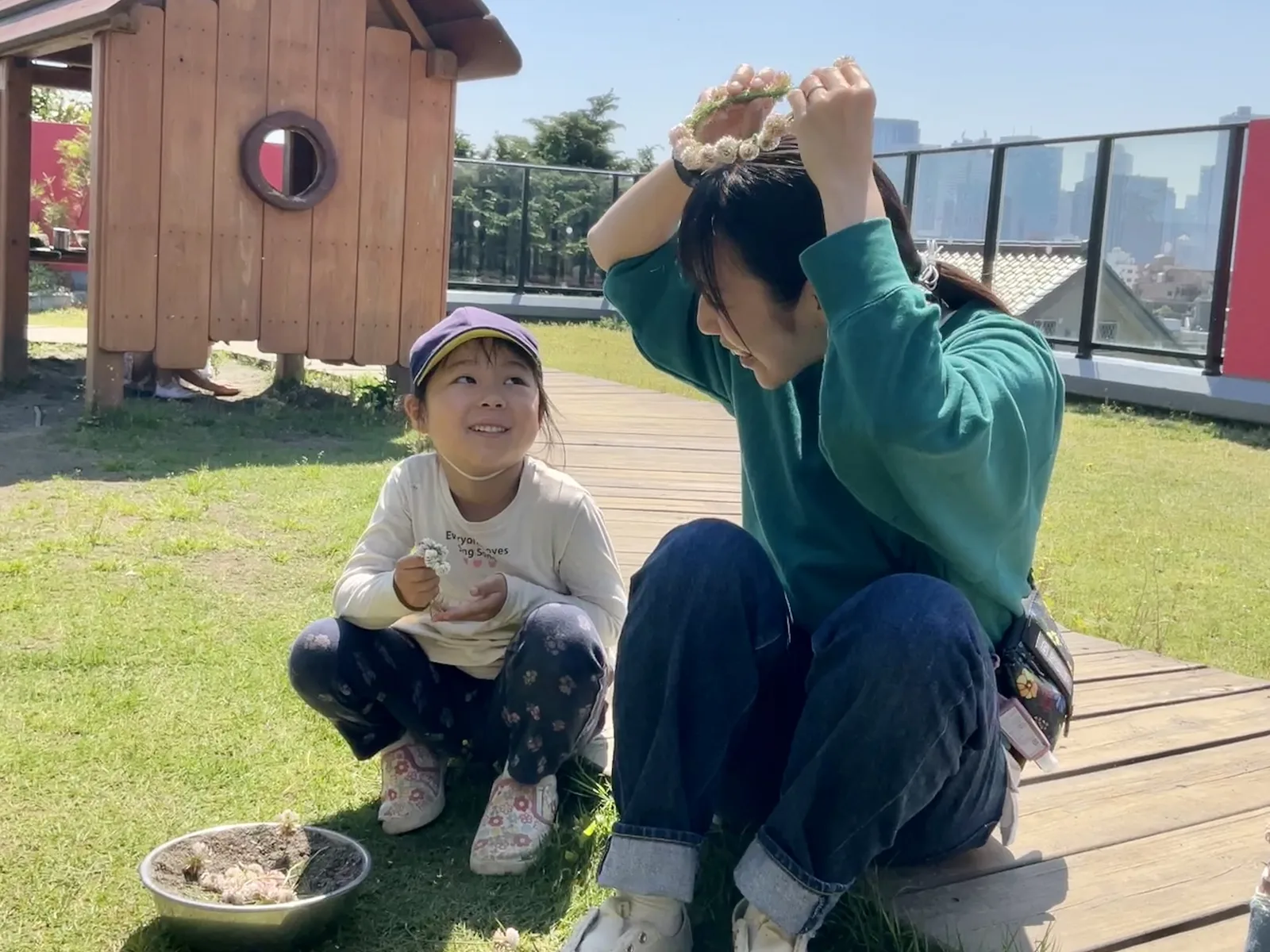 緑豊かな屋上園庭で園児とあそぶ保育士（アルテ子どもと木幼保園）